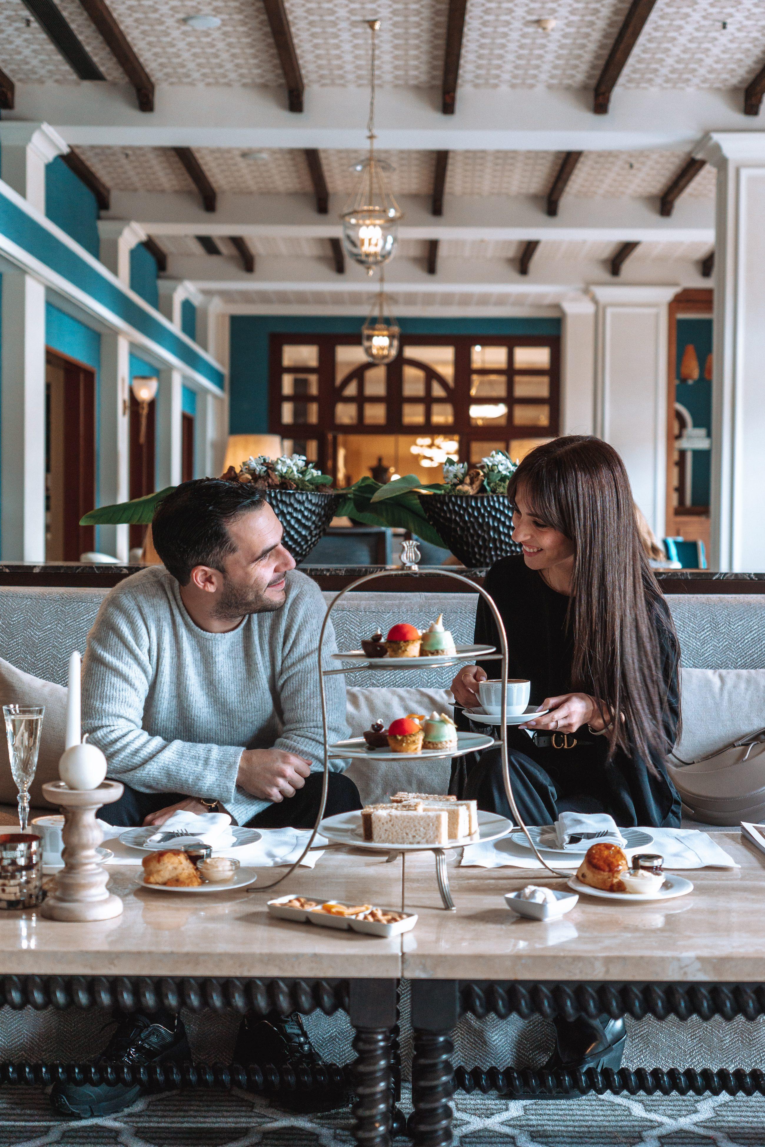 Couple having tea and desserts in a hotel lobby