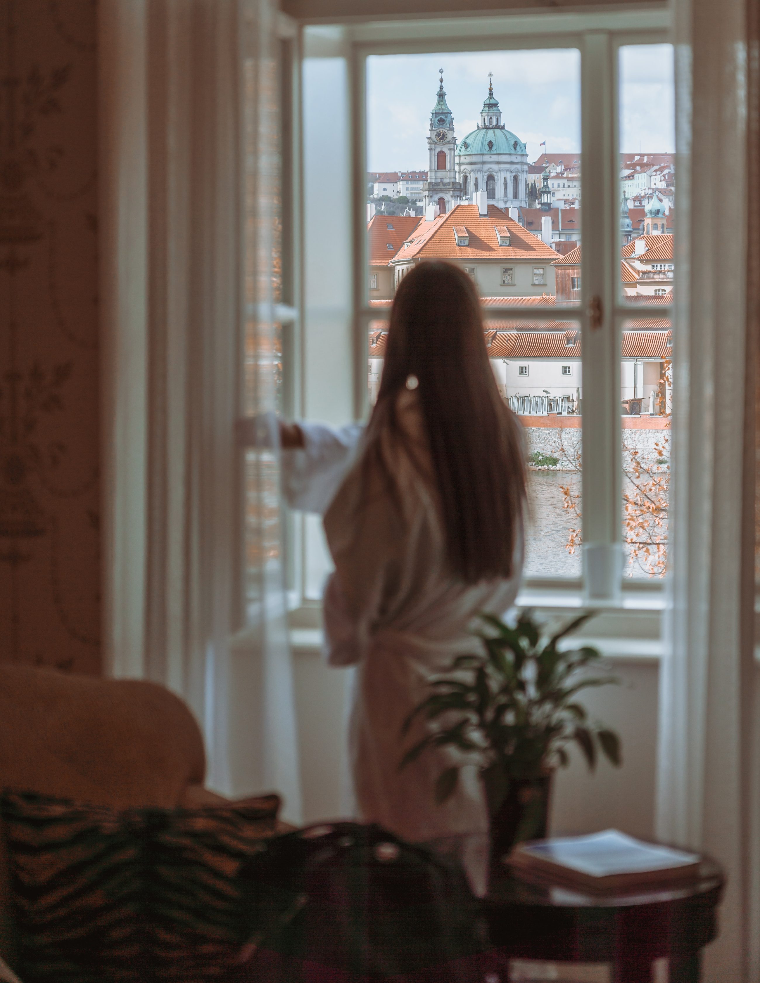 Woman gazing out of a European hotel window